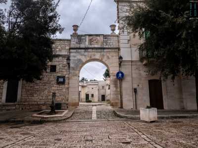 Per accedere alla corte in cui si trova il santuario oltrepassiamo un arco in pietra decorato da un bassorilievo della Vergine